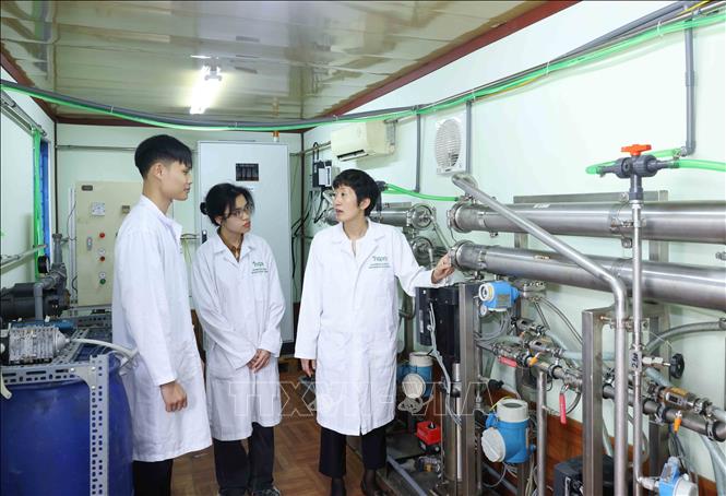 PGS.TS Nguyễn Minh Tân hướng dẫn sinh viên về hệ thống phân tách lọc nano cao áp dùng trong tinh chất các hợp thức thiên. Ảnh: Phương Hoa - TTXVN