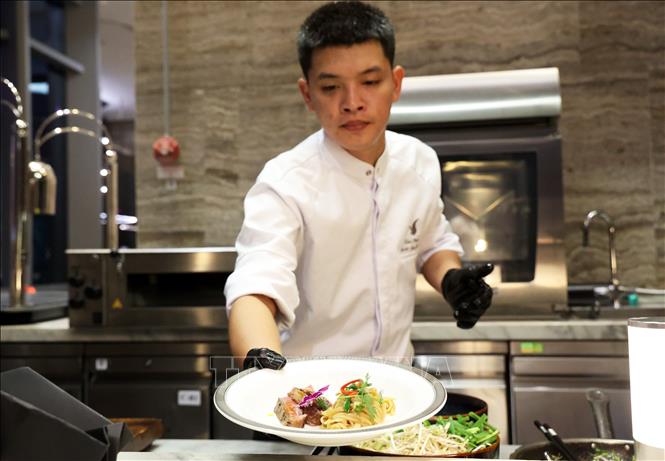 Đầu bếp giới thiệu món Phở xào ăn kèm với thịt bò thăn ngoại Satsuma Wagyu thượng hạng. Ảnh: Hồng Đạt - TTXVN
