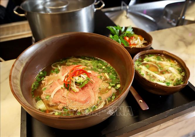 Phở chọc trời (Phở Lanmark81) với một phần lòng đỏ trứng gà chần được phục vụ trong một chiếc bát riêng. Ảnh: Hồng Đạt - TTXVN 