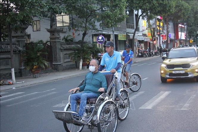 Khách du lịch tham quan thành phố Nha Trang trên chuyến xe của các đoàn viên Nghiệp đoàn xích lô thành phố Nha Trang. Ảnh: Phan Sáu - TTXVN
