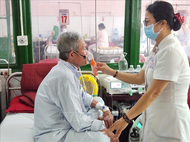 Điều dưỡng hỗ trợ người bệnh sử dụng máy oxy tự tạo. Ảnh: Mai Trang - TTXVN
