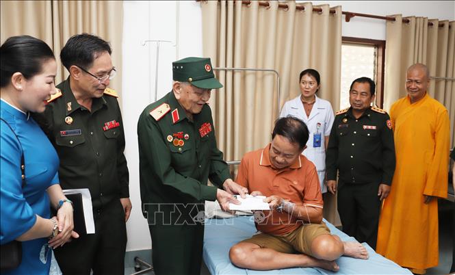 Thiếu tướng Võ Văn Chót, Trưởng ban danh dự Ban Liên lạc quân tình nguyện và chuyên gia quân sự Việt Nam giúp cách mạng Lào tỉnh Nghệ An, trao quà cho bệnh binh đang điều trị tại Bệnh viện Trung ương Quân đội 103 Lào. Ảnh: Xuân Tú - PV TTXVN tại Lào