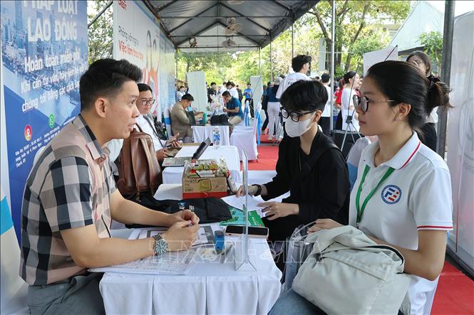 Ông Nguyễn Phương Tài Lộc, Trưởng phòng nhân sự Công ty Cổ phần chăn nuôi C.P. Việt Nam (trái) tuyển dụng người lao động. Ảnh: Thanh Vũ-TTXVN
