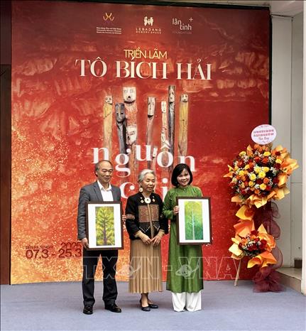 Nghệ sỹ Tô Bích Hải trao tặng Bảo tàng Phụ nữ Việt Nam 2 bức tranh do bà sáng tác. Ảnh: Phương Lan - TTXVN