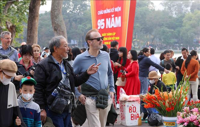 Foreign tourists stroll on streets around Hoan Kiem Lake in Hanoi. VNA Photo: Phạm Kiên 