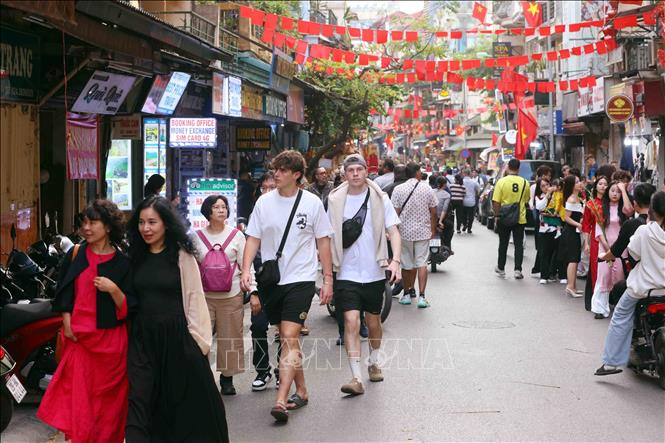 Foreign tourists stroll on Hanoi's streets. VNA Photo: Phạm Kiên 