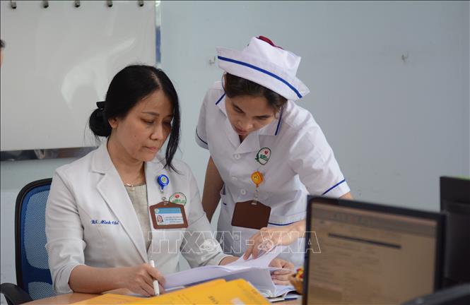 Bác sĩ Nguyễn Thị Minh Chí trao đổi công việc với nhân viên y tế. Ảnh: Văn Dũng-TTXVN