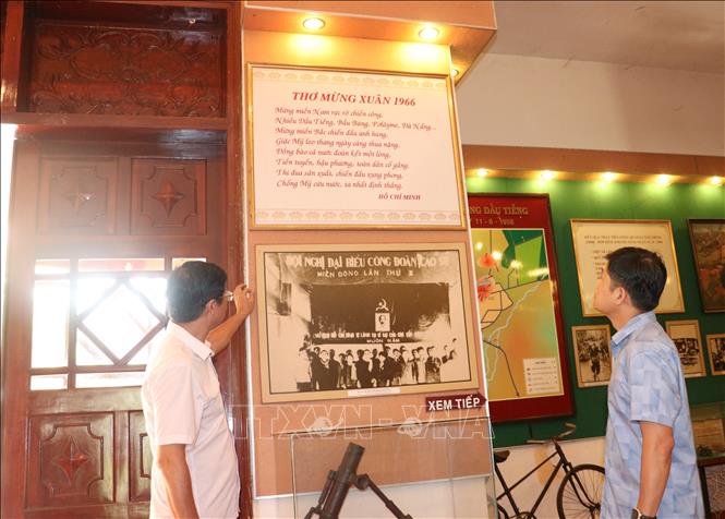Cán bộ ngành cao su tham quan, nghiên cứu tư liệu về bảo tàng chiến thắng Dầu Tiếng, trong đó có bài thơ chúc Tết năm 1966 của Chủ tịch Hồ Chí Minh. Ảnh: Dương Chí Tưởng-TTXVN