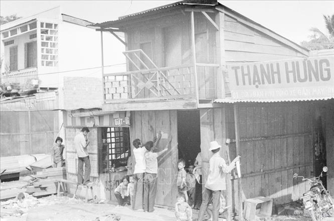 Người dân thị xã Buôn Mê Thuột xóa bỏ khẩu hiệu của địch, dán thông cáo phổ biến các chính sách của chính quyền cách mạng (tháng 3/1975). Ảnh: Anh Tôn- TTXVN