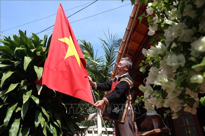 Già làng Y’Siu Byă, buôn Mduk, phường Ea Tam, thành phố Buôn Ma Thuột treo cờ Tổ quốc chào mừng 50 năm Chiến thắng Buôn Ma Thuột, giải phóng tỉnh Đắk Lắk. Ảnh: Tuấn Anh - TTXVN