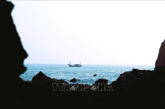 Thuyền đánh cá của ngư dân Quỳnh Lưu ra khơi men theo các rặng núi đá. Ảnh: Xuân Tiến - TTXVN 