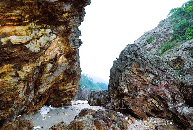 Con đường ven biển lộ diện khi thủy triều rút len lỏi dưới những vách đá với lớp lớp, tầng tầng địa chất rất đẹp. Ảnh: Xuân Tiến - TTXVN 