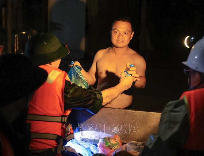 Ngay trong đêm 10/9/2024, cán bộ, chiến sĩ Lữ đoàn 210 đưa lương thực, nước uống đến tận tay người dân bị cô lập do nước lũ ở thành phố Thái Nguyên. Ảnh: Hoàng Hiếu - TTXVN