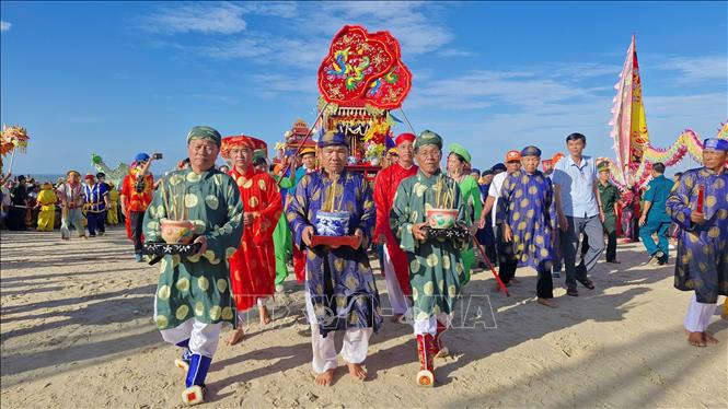 Đội rước lễ cùng các hương chức, ban tế tự Dinh Cô rước bài vị Cô từ biển vào bờ. Ảnh: Huỳnh Sơn-TTXVN