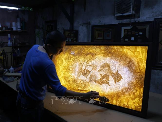 Sau khi tranh khô, người thợ sẽ lắp đặt đèn phía sau và đặt trong khung phủ kính hoặc mica phía trên là xong một sản phẩm tranh Trúc Chỉ hoàn chỉnh. Ảnh: Phạm Hậu - TTXVN