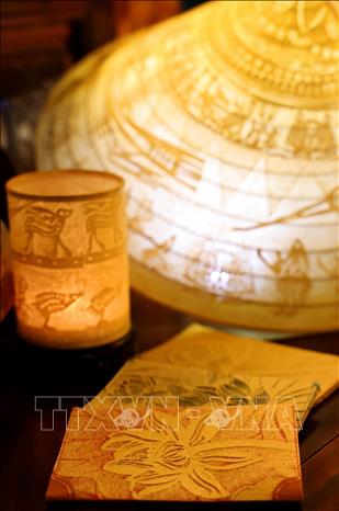Nghệ thuật Trúc Chỉ không những có khả năng thích ứng cao với nghệ thuật thị giác, mà còn với cả nghệ thuật ứng dụng như: nón lá, chao đèn nến, bìa hộ chiếu. Ảnh: Phạm Hậu - TTXVN