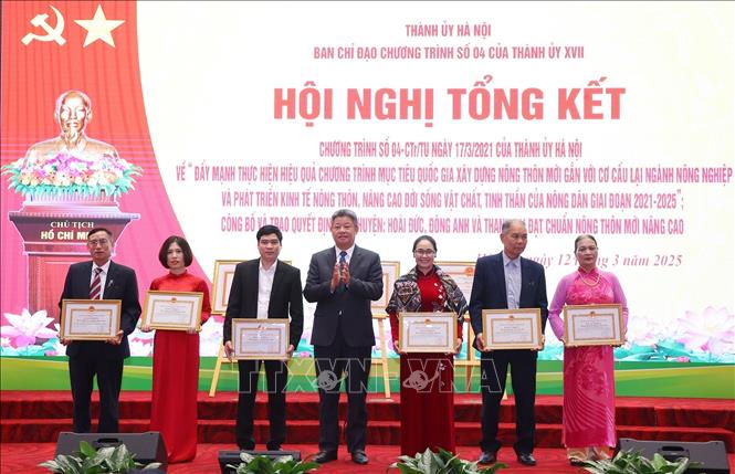 Phó Chủ tịch UBND thành phố Hà Nội Nguyễn Mạnh Quyền trao Bằng khen của Chủ tịch UBND thành phố tặng các hộ gia đình. Ảnh: Văn Điệp - TTXVN