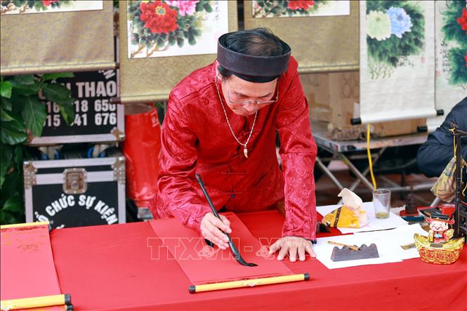 Viết thư pháp tại lễ hội. Ảnh: Mạnh Tú - TTXVN