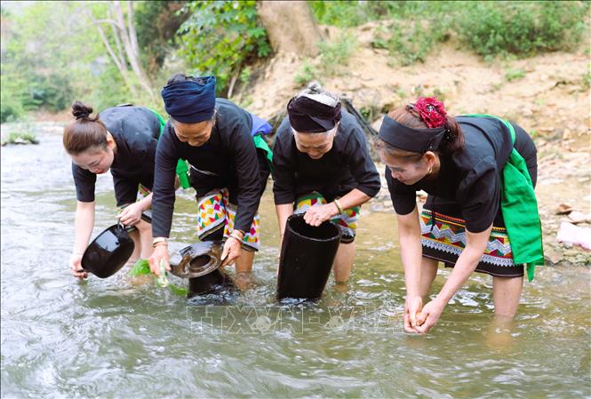 Các bà, các mẹ và chị em phụ nữ dân tộc Ơ Đu chùi rửa xoong nồi và những quả trứng gà để cầu mong những điều mới mẻ, may mắn sẽ đến trong năm mới. Ảnh: Xuân Tiến - TTXVN 