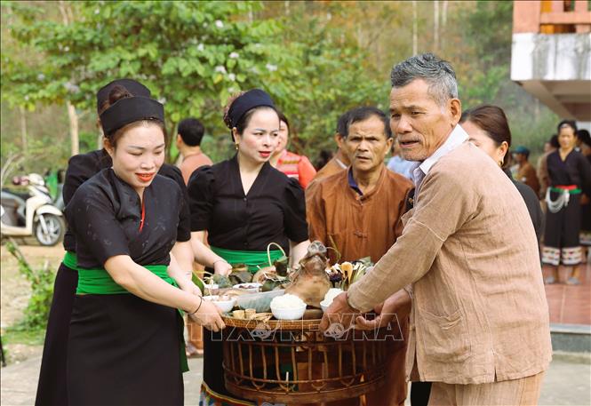 Người dân Ơ Đu di chuyển mâm cúng thần Sấm ra địa điểm cúng được thực hiện ngoài trời. Ảnh: Xuân Tiến - TTXVN 
