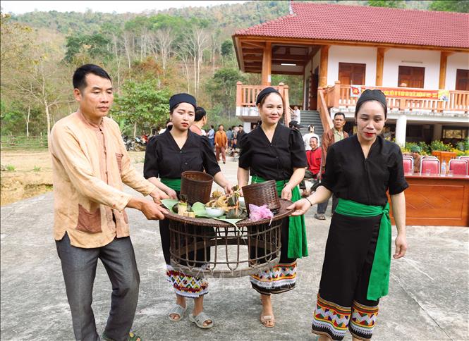 Người dân Ơ Đu di chuyển mâm cúng làm vía cho dân trong bản ra địa điểm cúng. Ảnh: Xuân Tiến - TTXVN 