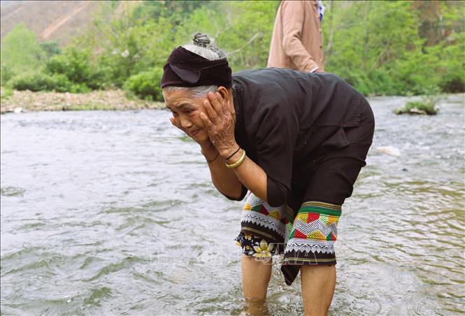 Người già dân tộc Ơ Đu ra suối rửa mặt trong sáng sớm để cầu mong đón năm mới dồi dào sức khỏe, rửa bỏ được những điều đen đủi, không may của năm cũ. Ảnh: Xuân Tiến - TTXVN 