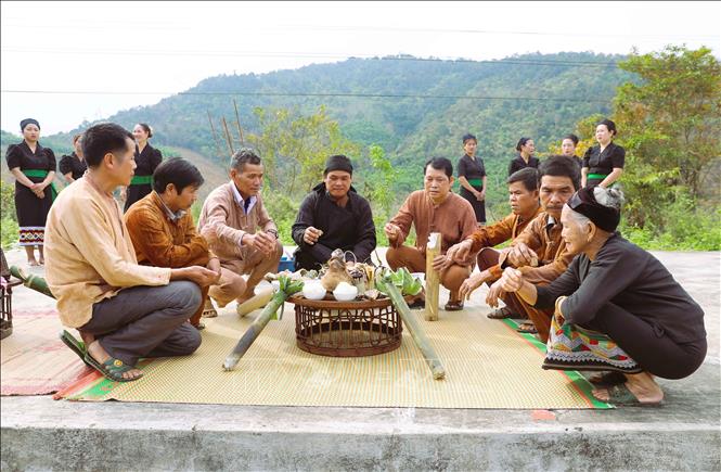 Thầy mo là chủ lễ và các vị già làng, người có uy tín trong bản nâng chén rượu đầu năm ở mâm cúng thần Sấm để cầu mong những điều tốt đẹp đến với bản làng trong năm mới. Ảnh: Xuân Tiến - TTXVN 
