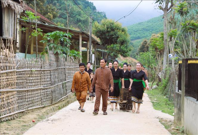 Thầy mo của bản Văng Môn dẫn đường đưa người dân về địa điểm tiến hành các lễ thức cúng cầu may trong ngày đầu năm mới. Ảnh: Xuân Tiến - TTXVN 