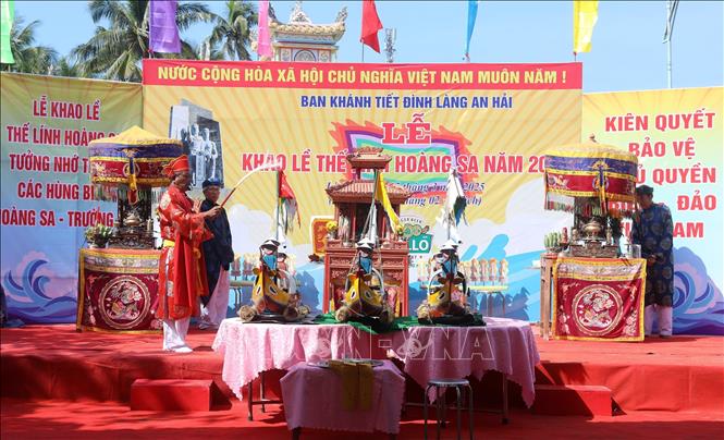 Thầy pháp thực hiện nghi thức thế lính - nghi lễ cúng thế mạng cho những người lính thủy quân Hoàng Sa trước khi thả thuyền ra biển. Ảnh: Quốc Khánh - TTXVN