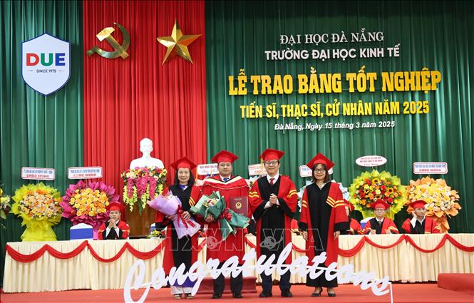 Lãnh đạo trường Đại học Kinh tế-Đại học Đà Nẵng trao bằng Tiến sĩ cho nghiên cứu sinh. Ảnh: Văn Dũng-TTXVN