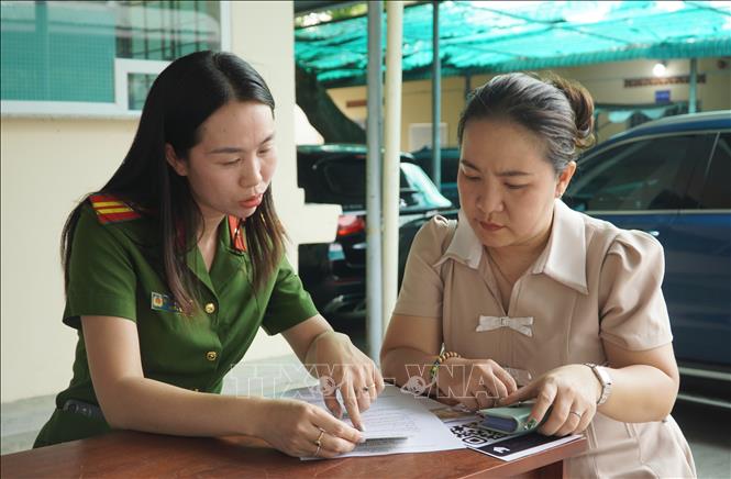 Cán bộ Công an phường Bình Thọ hướng dẫn làm thủ tục cho người dân. Ảnh: Trung Tuyến - TTXVN