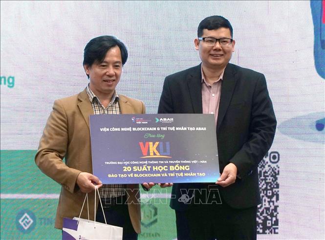 Ông Nguyễn Đức Long, Giám đốc Chuyển đổi số, Viện Công nghệ Blockchain và Trí tuệ Nhân tạo (phải) trao tặng 20 suất học bổng đào tạo Blockchain và Trí tuệ nhân tạo (AI) cho sinh viên Trường Đại học Công nghệ Thông tin và Truyền thông Việt Hàn. Ảnh: Quốc Dũng - TTXVN