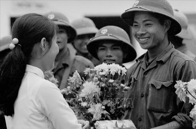 Nữ sinh trường Bồ Đề (Đà Nẵng) tặng hoa chào đón các chiến sĩ vào giải phóng thành phố. Ảnh: Quang Thành - TTXVN
