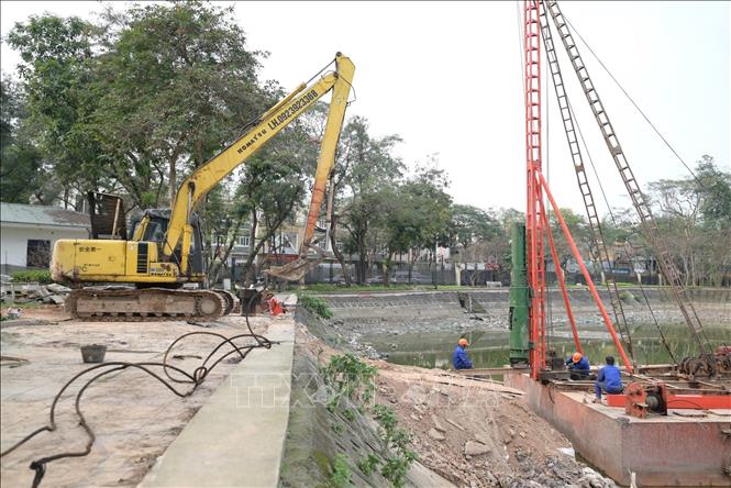 Đơn vị thi công đang khẩn trương ép cọc bê tông để xây trụ cầu đi bộ trong công viên. Ảnh: Lương Hiếu/TTXVN phát