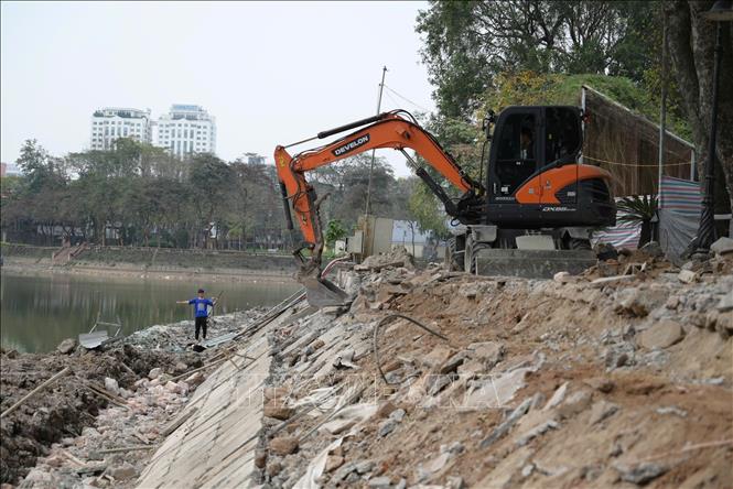Đơn vị thi công dùng máy cào hết lớp kè cũ để xây dựng lớp kè mới. Ảnh: Lương Hiếu/TTXVN phát