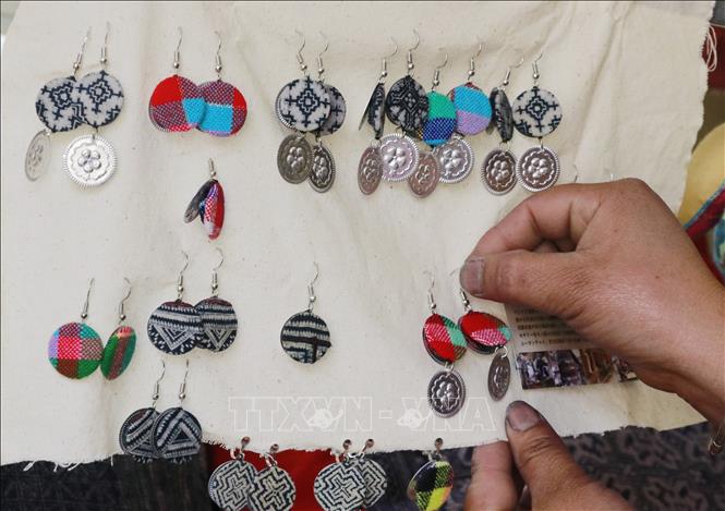 With skillful hands and rich imaginations, the Mong women in Che Cu Nha commune, Mu Cang Chai district, Yen Bai province have utilized beeswax to create unique decorative patterns on traditional brocade, enhancing the beauty of various products such as handbags, wallets, scarves, and clothing. VNA Photo: Đinh Thùy