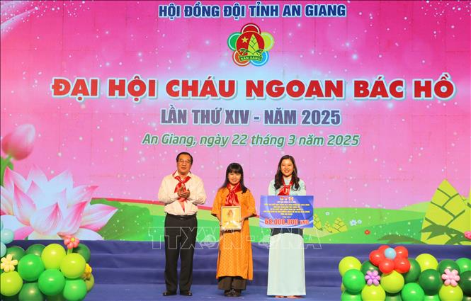 Bà Ngô Hồng Phước, Trưởng Văn phòng đại diện Quỹ học bổng Vừ A Dính và Báo Thiếu niên tiền phong & Nhi đồng tại Khu vực phía nam (giữa), Đại diện Quỹ học bổng Vừ A Dính trao bảng tượng trưng học bổng Vừ A Dính và học bổng Vòng tay nhân ái cho các học sinh. Ảnh: Công Mạo-TTXVN