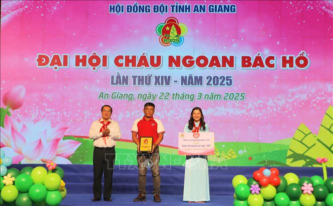 Đại diện Công ty Cổ phần Sữa quốc tế LOF trao bảng tượng trưng nguồn lực hỗ trợ sữa và dụng cụ học tập trị giá 100 triệu đồng cho Hội đồng Đội tỉnh An Giang. Ảnh: Công Mạo-TTXVN