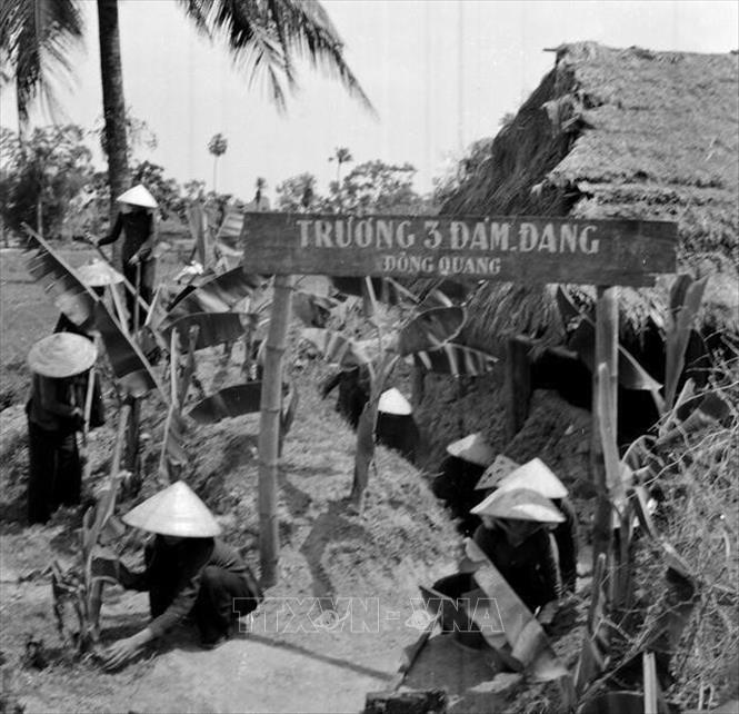 Phụ nữ Việt Nam thời nào cũng luôn mang trong mình những phẩm chất cao quí mà Bác Hồ đã từng trao tặng “Anh hùng – Bất khuất – Trung hậu – Đảm đang”. Trong ảnh: Học viên trường 3 đảm đang (xã Đông Quang, huyện Đông Sơn,Thanh Hóa) sửa chữa lại hầm hào, trồng cây xung quanh trường (1968). Ảnh: TTXVN