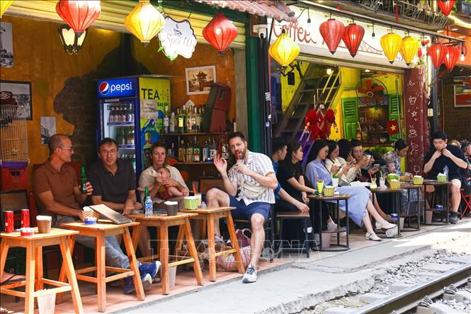 Du khách thư giãn, tận hưởng không khí đặc trưng của quán cà phê ven đường ray. Ảnh: Ngọc Anh/TTXVN phát