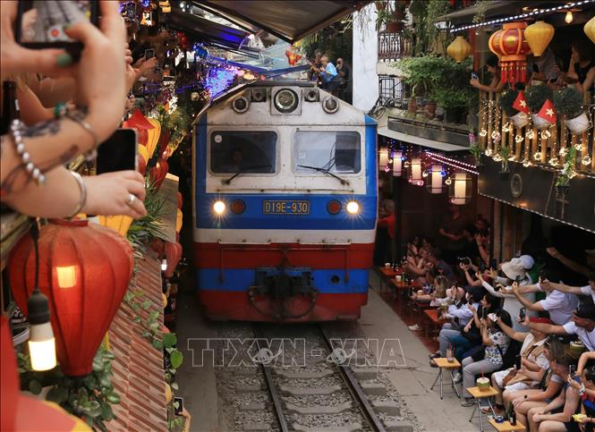 Thời điểm tàu chạy qua, du khách vẫn háo hức chụp ảnh dù nguy hiểm cận kề. Ảnh: Thành Phương - TTXVN