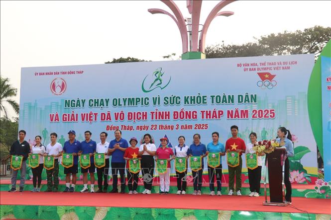 Ban tổ chức tặng cờ lưu niệm cho các đơn vị tham gia Ngày chạy Olympic vì sức khoẻ toàn dân tỉnh Đồng Tháp năm 2025. Ảnh: Nguyễn Văn Trí - TTXVN