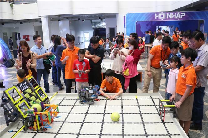 Học sinh tham gia trải nghiệm điều khiển robot gắp bóng.  Ảnh: Văn Dũng-TTXVN