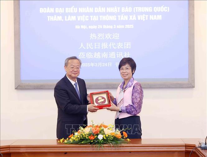 Tổng Giám đốc TTXVN Vũ Việt Trang tặng quà lưu niệm cho Tổng Biên tập Nhân dân nhật báo Trần Kiến Văn. Ảnh: Phương Hoa – TTXVN