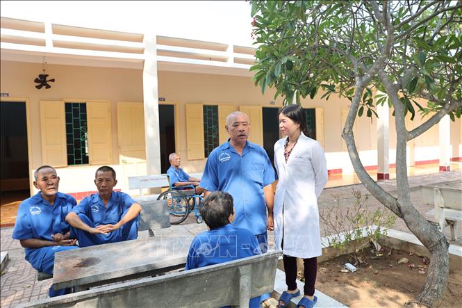 Cán bộ Trung tâm Điều dưỡng thương binh và người có công Long Đất thăm hỏi các thương bệnh binh. Ảnh: Hoàng Nhị - TTXVN
