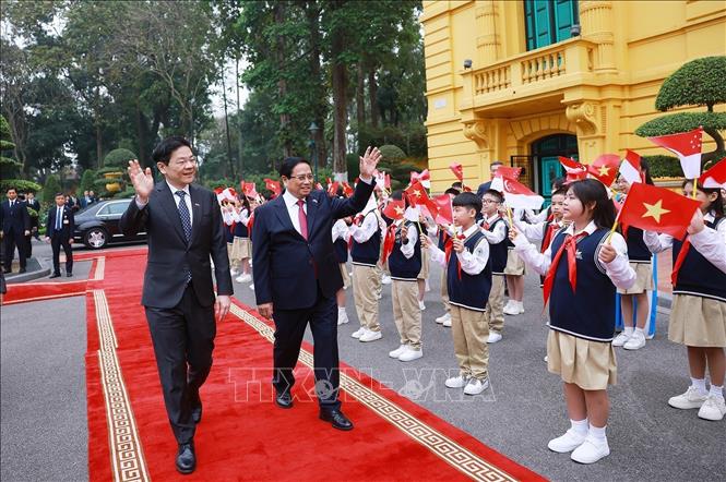 Prime Minister Pham Minh Chinh hosts a ceremony to welcome Singaporean Prime Minister Lawrence Wong in Hanoi on March 26. VNA Photo: Dương Giang