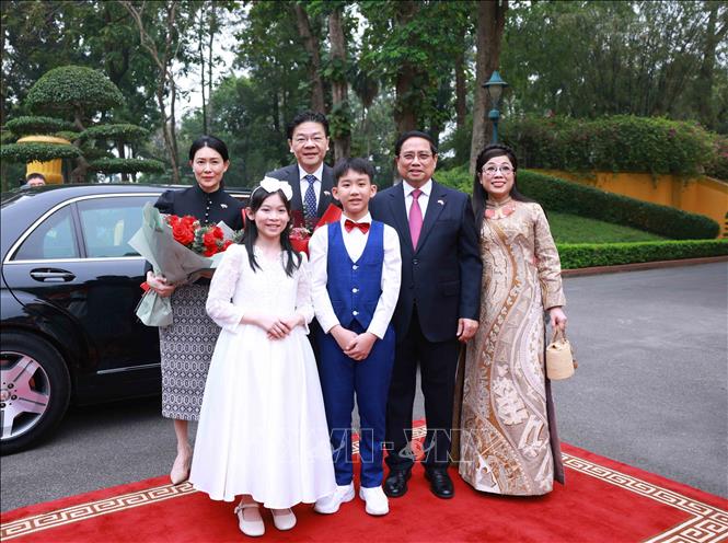 Prime Minister Pham Minh Chinh and his spouse host a ceremony to welcome Singaporean Prime Minister Lawrence Wong and his spouse in Hanoi on March 26. VNA Photo: Dương Giang