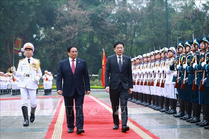 Prime Minister Pham Minh Chinh and Singaporean Prime Minister Lawrence Wong review the guards of honour at the ceremony. VNA Photo: Dương Giang