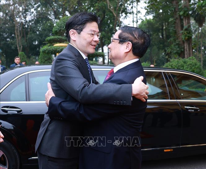 Prime Minister Pham Minh Chinh welcomes Singaporean Prime Minister Lawrence Wong in Hanoi on March 26. VNA Photo: Dương Giang