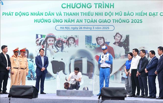 Màn kiểm chứng, thử nghiệm chất lượng mũ bảo hiểm đạt chuẩn tại sự kiện. Ảnh: Minh Đức – TTXVN